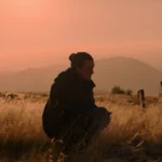 Ellie (Bella Ramsey) với biểu cảm trầm tư trong The Last of Us mùa 2, thể hiện sự chờ đợi và hoài nghi của người hâm mộ.