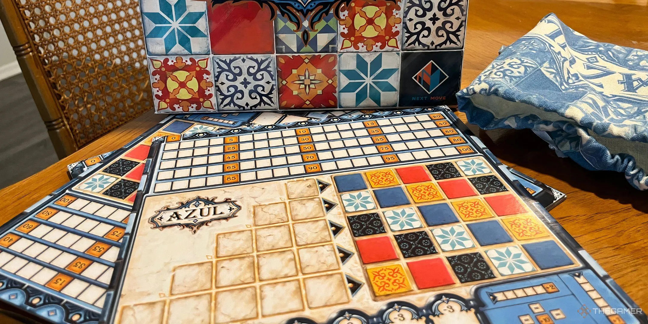 Hộp và bàn chơi game Azul với những viên gạch đầy màu sắc được sắp xếp tinh tế, minh họa nghệ thuật lát gạch.