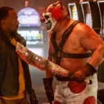 Sweet Tooth kề mã tấu đẫm máu vào cổ John Doe trong phim Twisted Metal